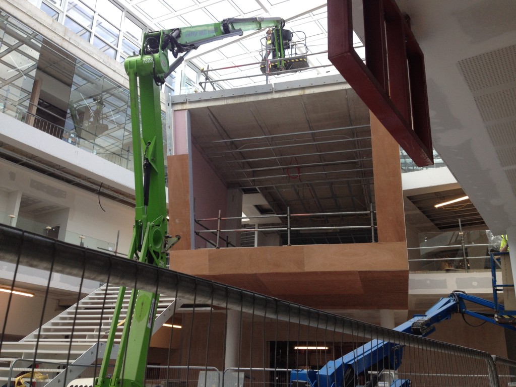 A cantilevered cube meeting space project out into the atrium from the first floor.