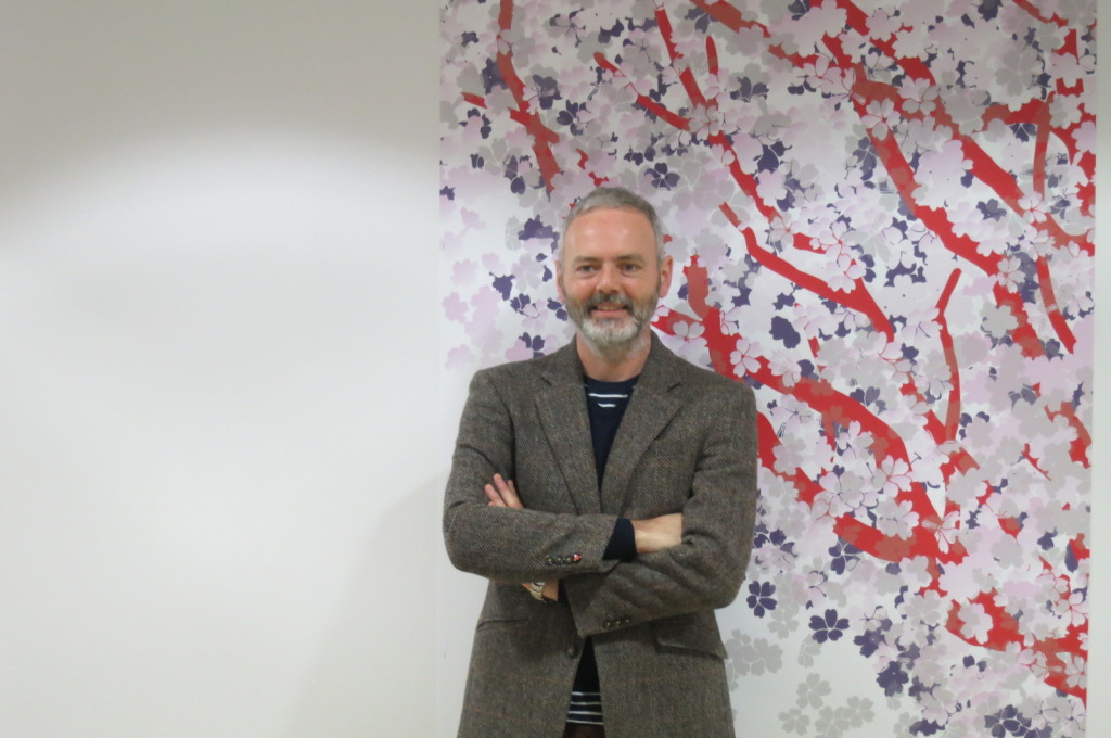 Christopher Tipping, the project artist standing next to a sample wall covering installation on the wards at The Whiteleaf Centre.  Image: Tom Cox 