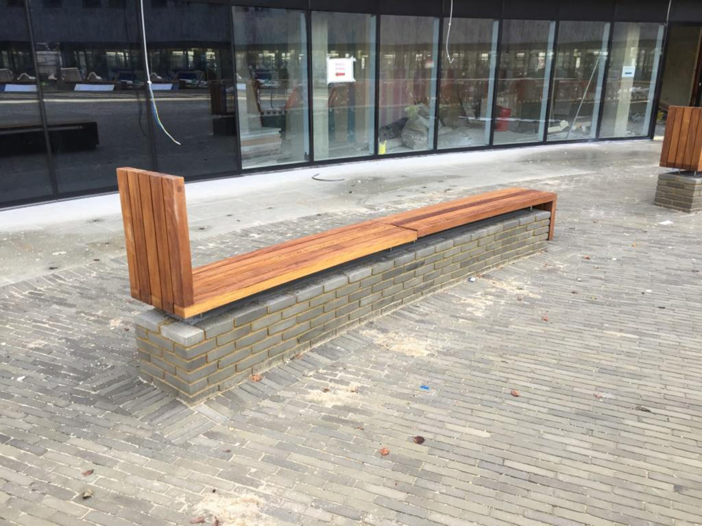 The timber benches sit atop a brick built plinth, which mirrors the semi circular setting out of the site. The benches here have not be fully installed and fastened. 