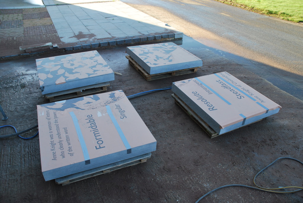The four granite slabs which make up the large platform seat awaiting more sandblasting outside.