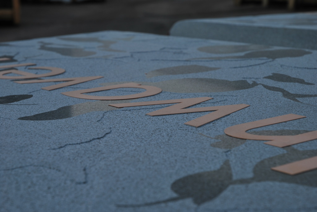 The sandblast is no more than 2mm deep across the slab. The fine honed finish on the surface will be retained under the vinyl which still covers the letters.