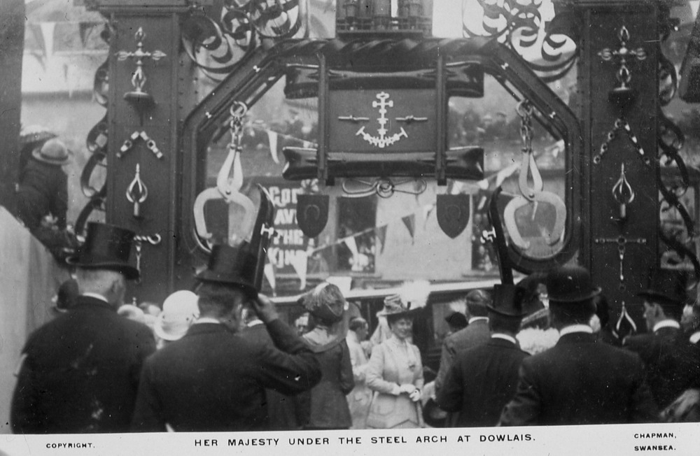 Image: Detail of the Royal Visit to Dowlais in 1912 and the steel Goat Mill Arch erected to mark the occasion.  Image by permission of http://www.alangeorge.co.uk/