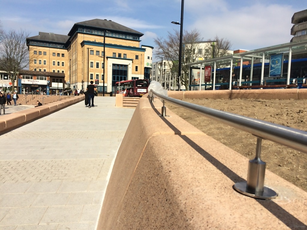 Bespoke cast concrete large retaining wall - aka The No.6 Feature - with stainless railing detail. Skandia House on Commercial Road is in the background.  Southampton Station Quarter North Project. Image by Project Artist Christopher Tipping